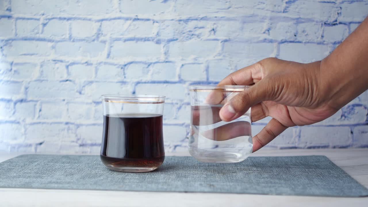 Confronto tra bibite analcoliche e un bicchiere d'acqua sul tavolo