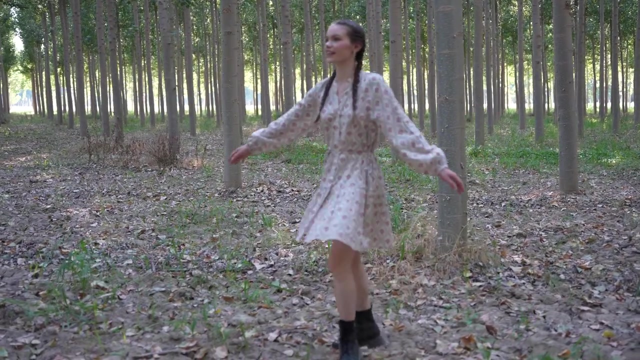 Una giovane donna in posa in un ambiente forestale sereno e tranquillo, circondata dalla bellezza della natura.