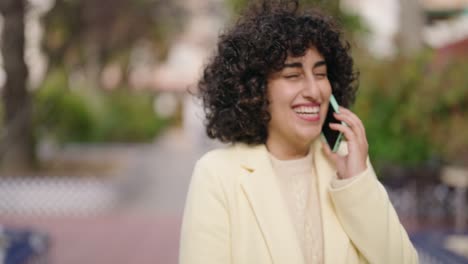 young woman smiling confident talking on the smartphone at park