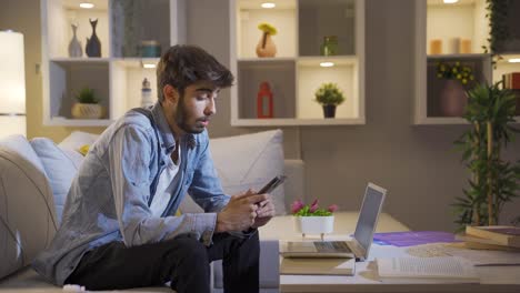 el hombre acostado en el sofá está usando el teléfono. postura agradable y cómoda.