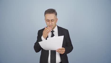 businessman examines paperwork and gets upset.