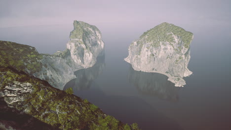 natural rock formations reflected in calm water during early morning