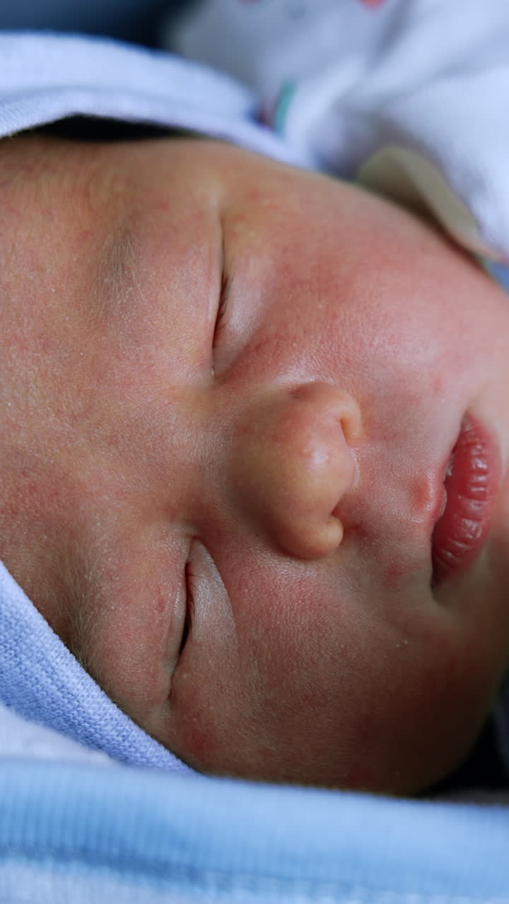 Lovely Caucasian newborn kid's face. Sleeping infant few days old close up portrait. Vertical video