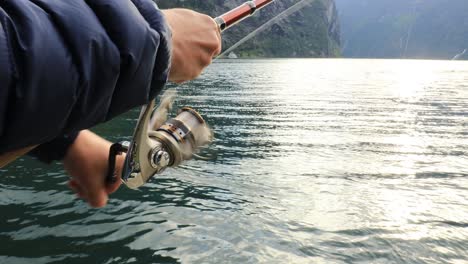 mujer pescando en una caña de pescar girando en noruega.