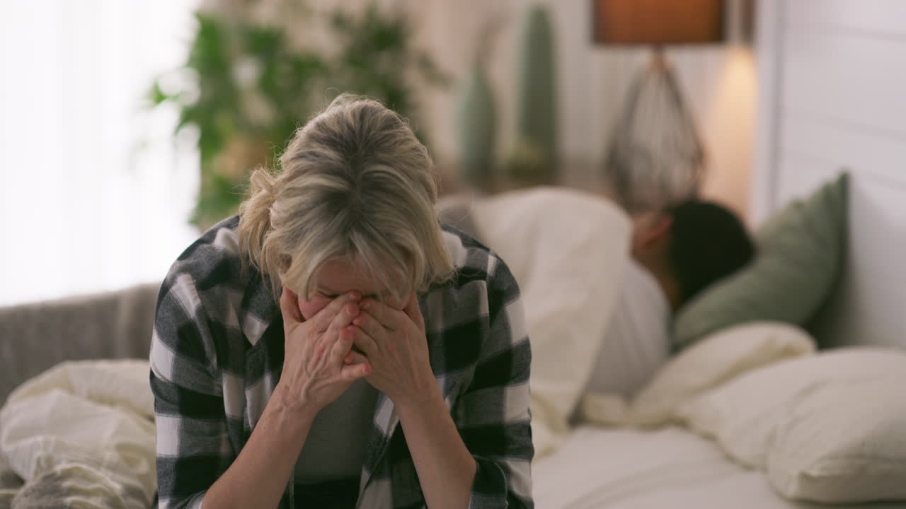 Mulher triste no quarto com o parceiro.