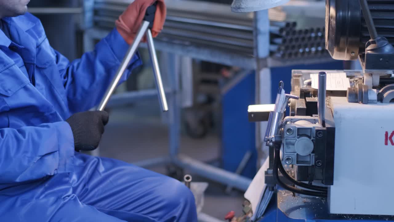 A worker in a factory makes parts using a semi-automatic method. Manufacturing of stainless steel products. Stainless steel pipes