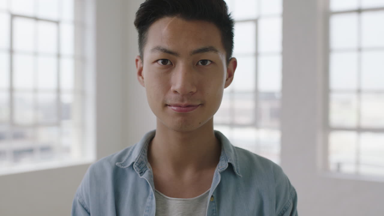 아파트 창문 배경의 카메라에 심각하고 자신감있는 젊은 아시아 십대 남자의 근접 초상화