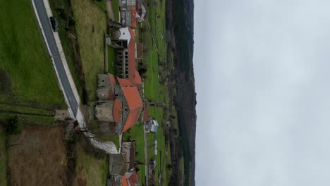 órbita-Aérea-Panorámica-Alrededor-Del-Monasterio-De-Santa-María-De-Xunqueira,-Vertical