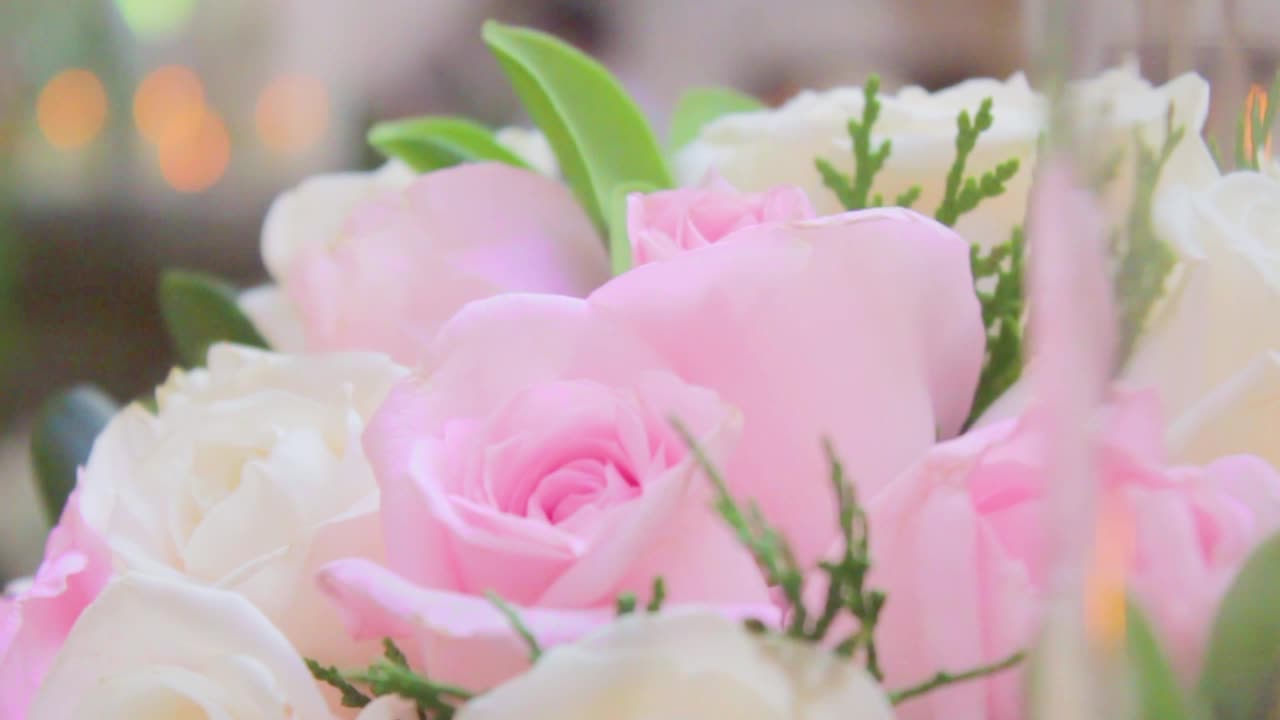 Floral arrangement with roses and a candle
