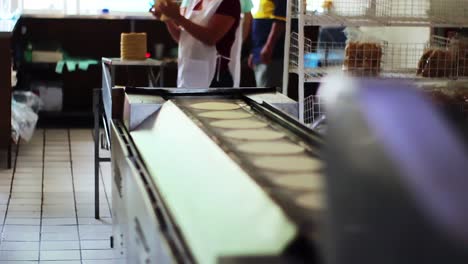 Fresh-corn-tortillas-out-of-the-tortilla-making-machine