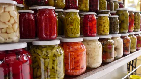 un estante de verduras encurtidas en tarros