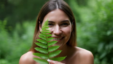 woman holding fern leaf