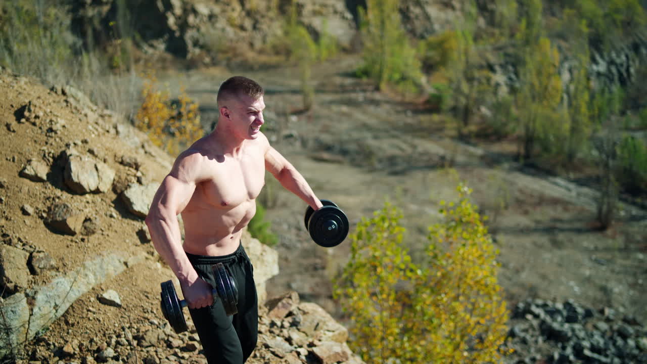 Sporty man with dumbbells. Muscular man exercising with dumbbells