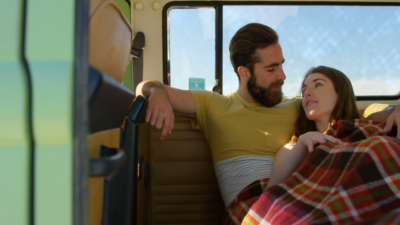 una pareja joven interactuando entre sí en una furgoneta 4k.