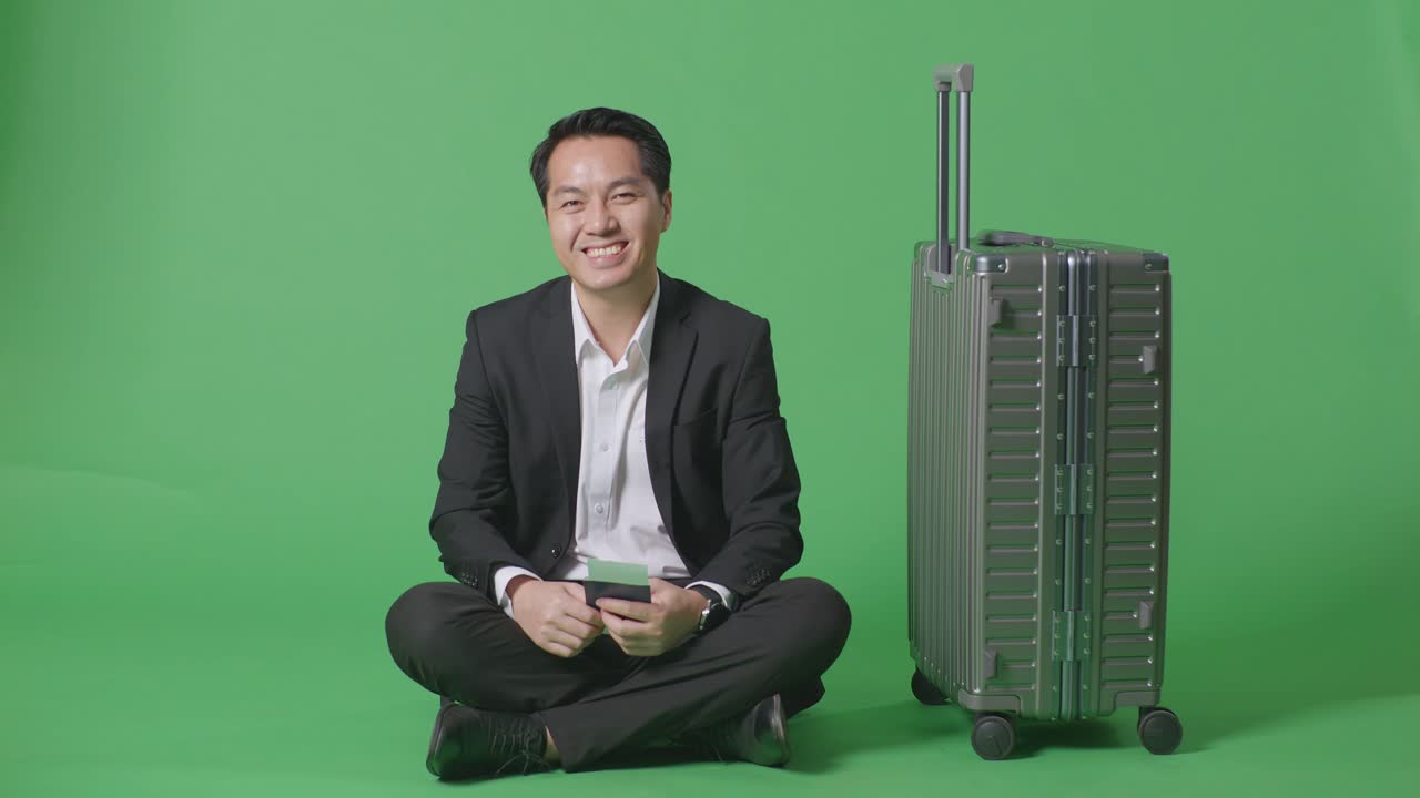 여행 을 준비 하고 있는 짐 을 들고 앉아 있는 사업가