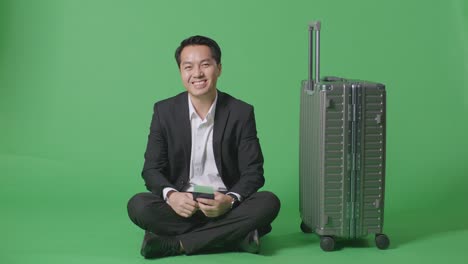 여행 을 준비 하고 있는 짐 을 들고 앉아 있는 사업가