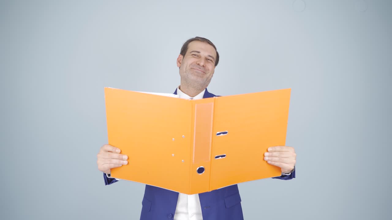 Businessman looking from behind files.