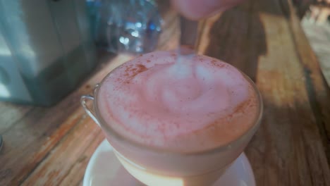 stirring a cappuccino at a restaurant