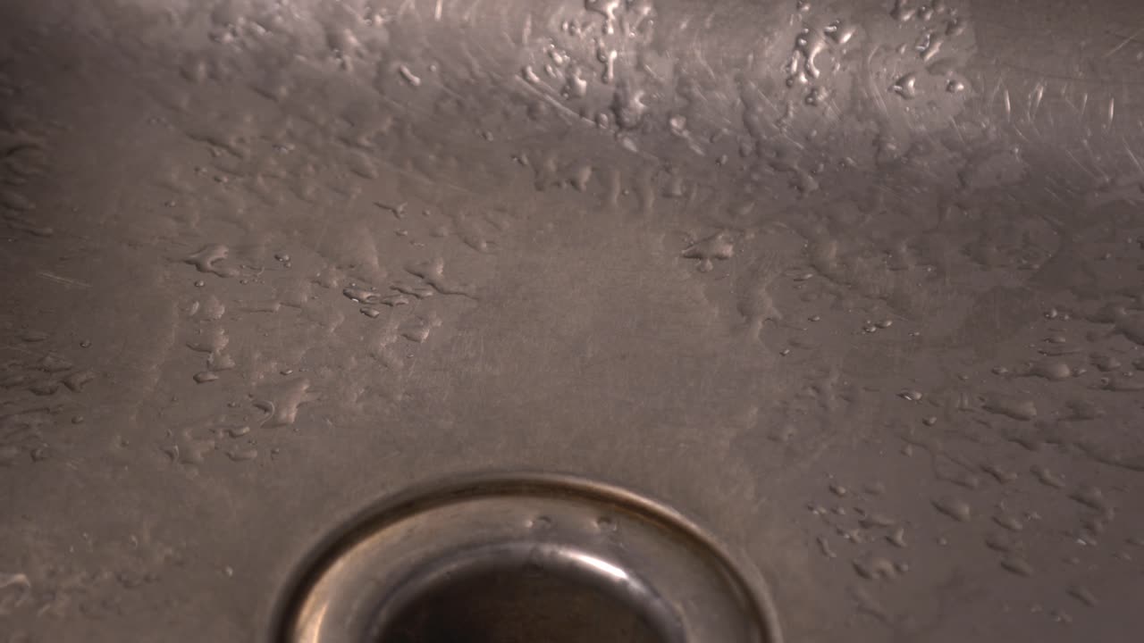 Waterdrops Splashing On The Stainless Kitchen Sink. - close up shot