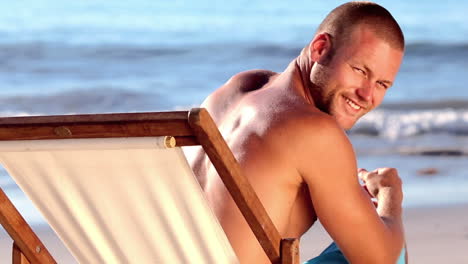 Handsome-man-with-a-straw-hat-relaxing-on-a-deck-chair