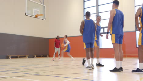 playing basketball, coach shooting ball while team watches in gymnasium