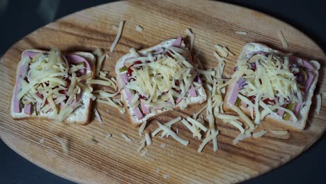 queso rallado cayendo suavemente sobre deliciosos sándwiches de desayuno