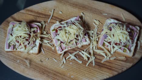 grated cheese smoothly falling on delicious breakfast sandwiches