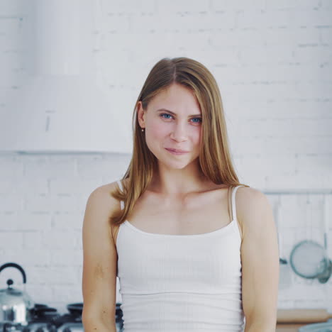 lovely woman in the modern kitchen. young happy female holding halves of oranges and closes her eyes by them. healthy lifestyle.