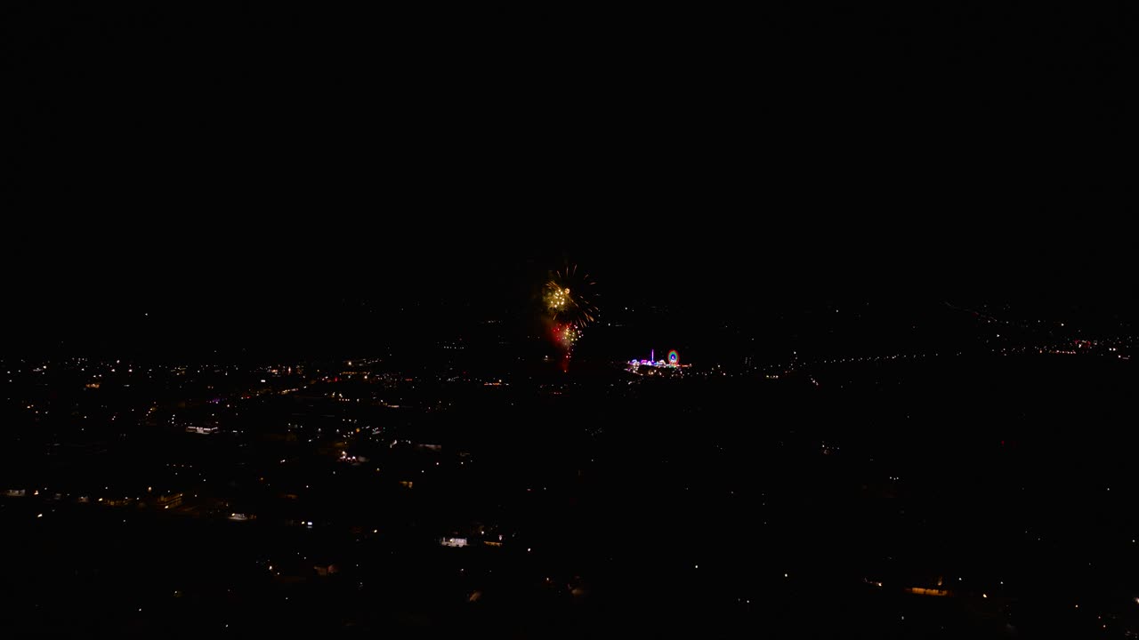 Aerial footage of a fireworks display at a county fair in small town at night time