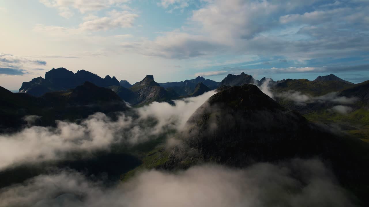 Flying through clouds in scenic Lofoten Islands, Norway. Mountain peaks and fjord landscape in summer