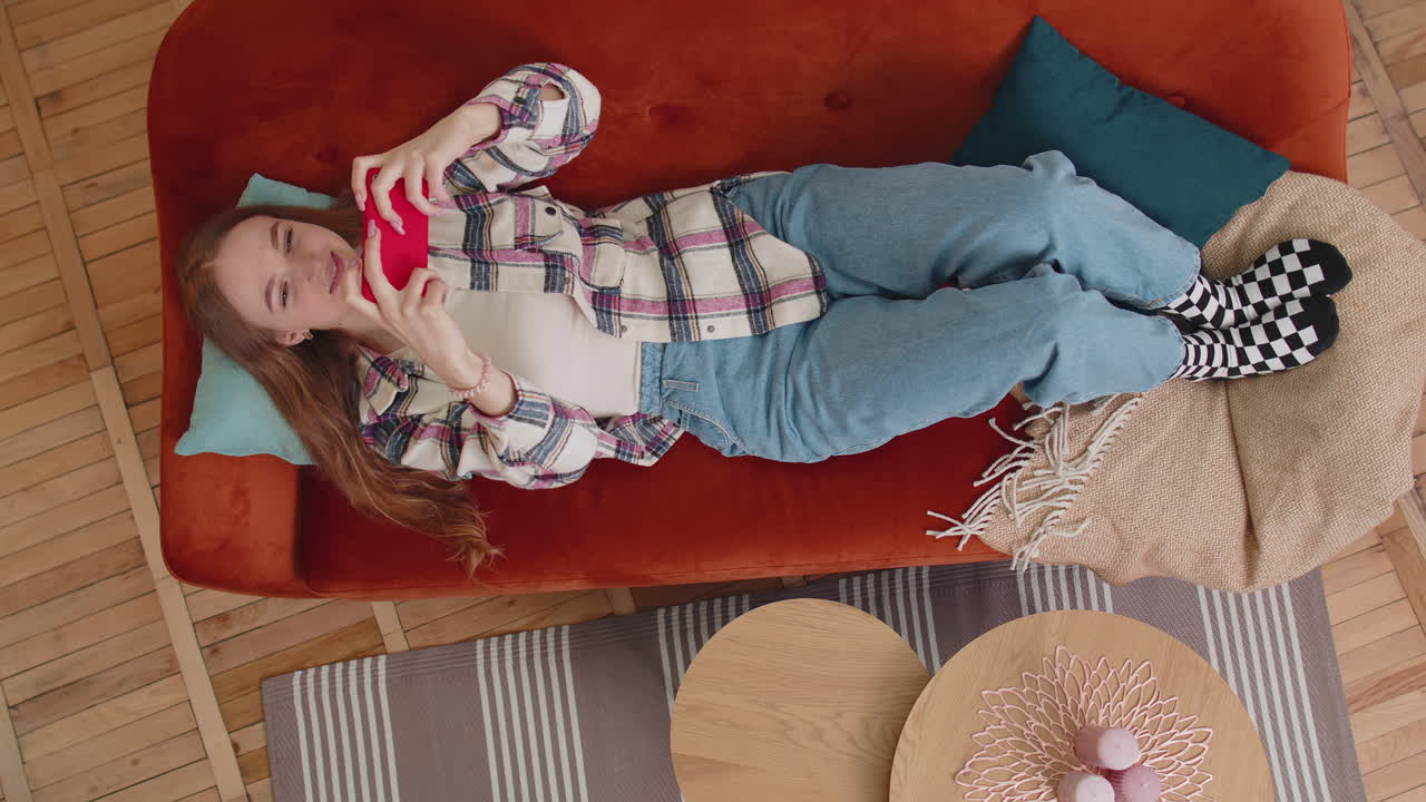 mujer adicta divertida y preocupada jugando con entusiasmo a videojuegos de carreras en el teléfono móvil en casa