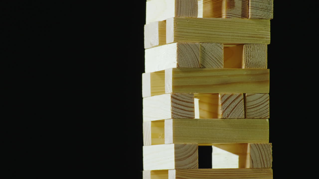 dos personas se turnan para sacar barras de madera de la torre jugando en jenga