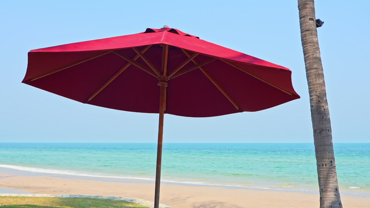 푸른 하늘과 바다 배경에 빨간 비치 파라솔 우산
