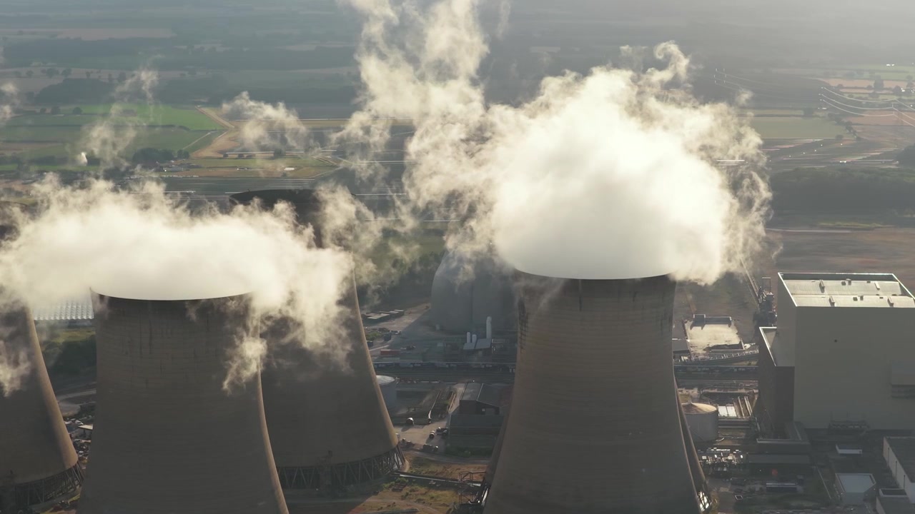 Spesso vapore bianco si innalza dalle torri di raffreddamento in cemento della centrale elettrica di Drax nel limpido cielo mattutino del North Yorkshire.