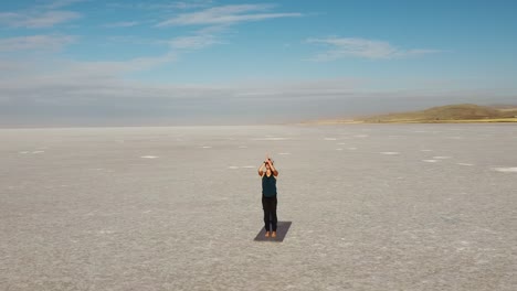 young woman praticing yoga in a wild place