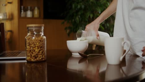 woman pouring milk for breakfast