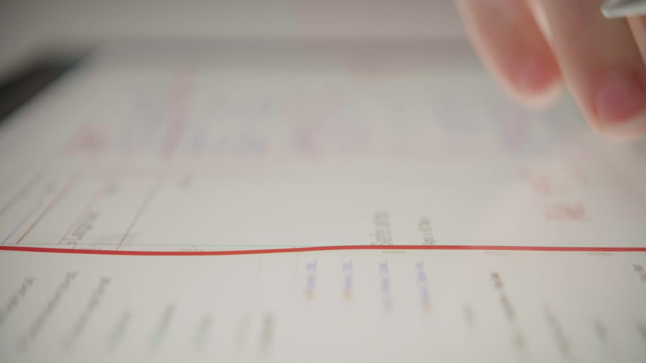 An extreme close-up shows a hand using a stylus to make notes on a digital document on a tablet. A concept for modern productivity, digital workflow, planning, and technology