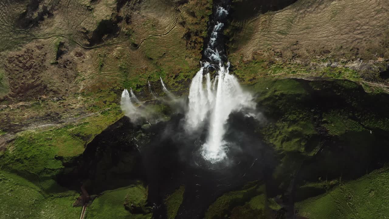 antena de arriba hacia abajo en la cascada que fluye seljalandsfoss en islandia volcánica salvaje