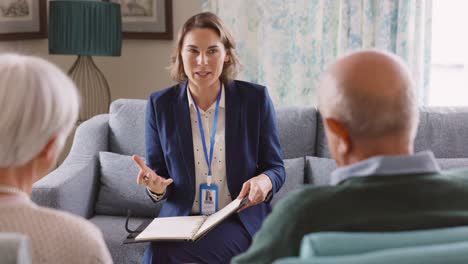 social worker talking to senior couple at home