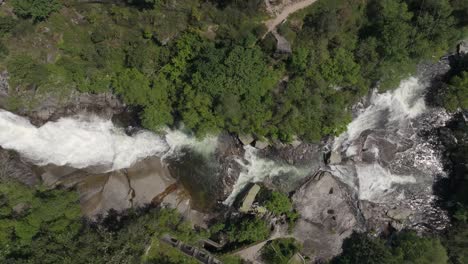bird's eye view over waterfall in segade, caldas de reis, galicia, spain - drone shot