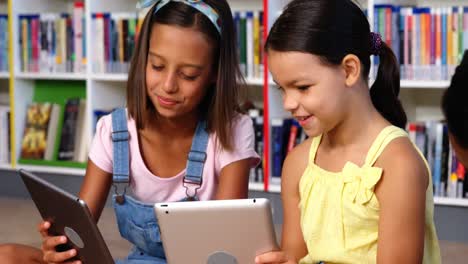 niños de la escuela usando tableta digital en la biblioteca