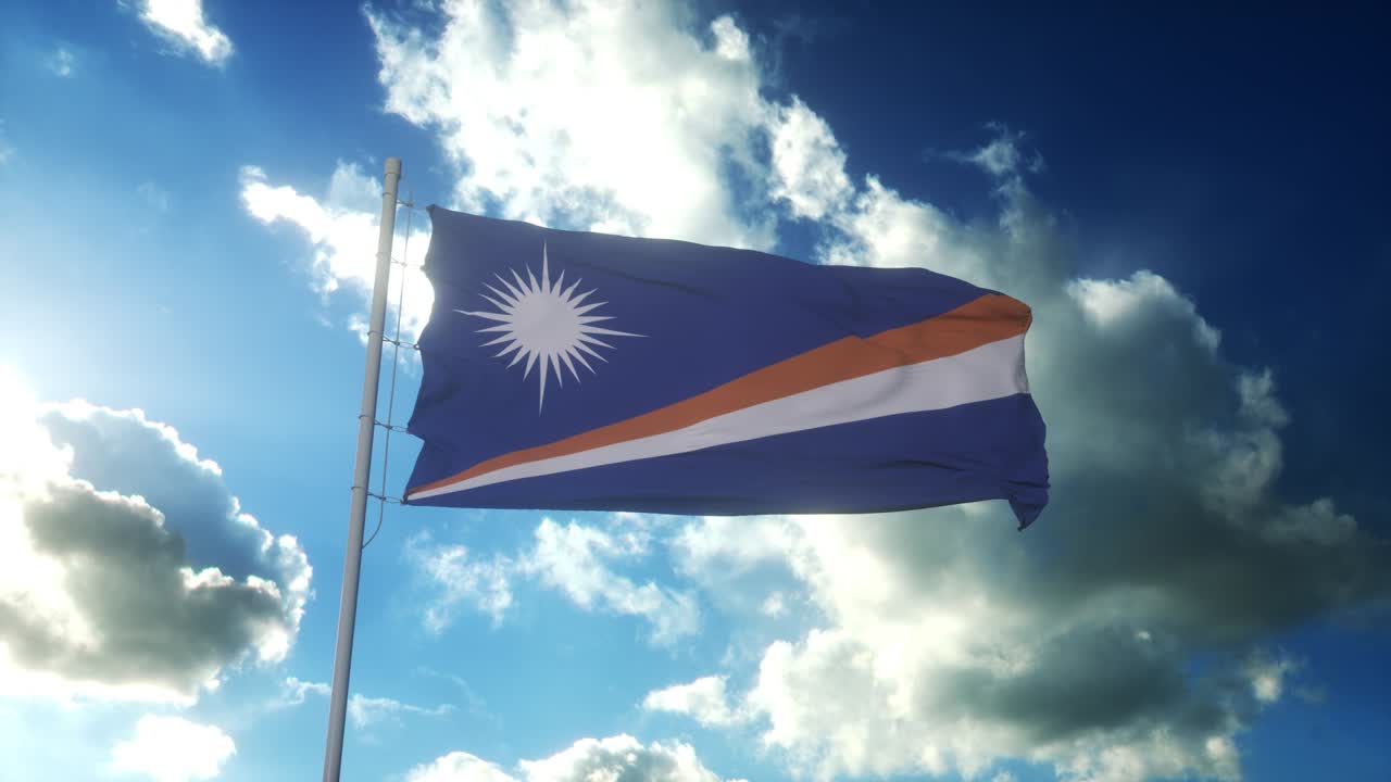 Flag of Marshall Islands waving at wind against beautiful blue sky