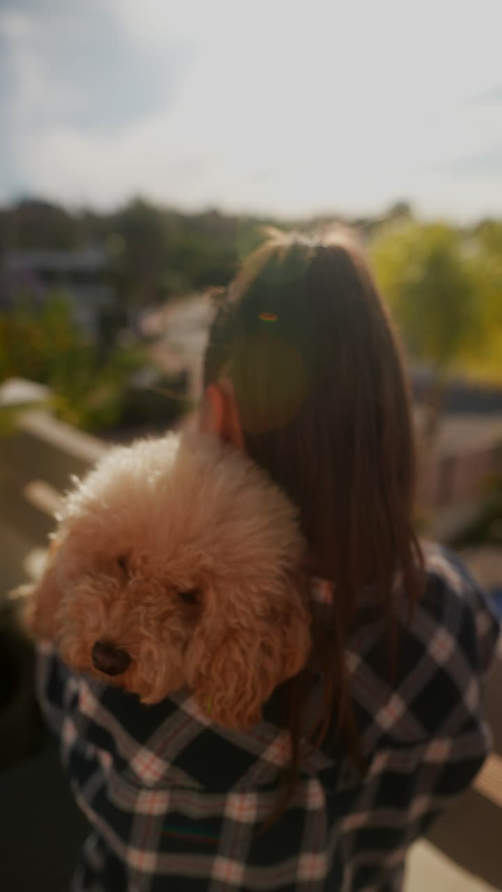 Girl Hugging a Poodle on a Balcony