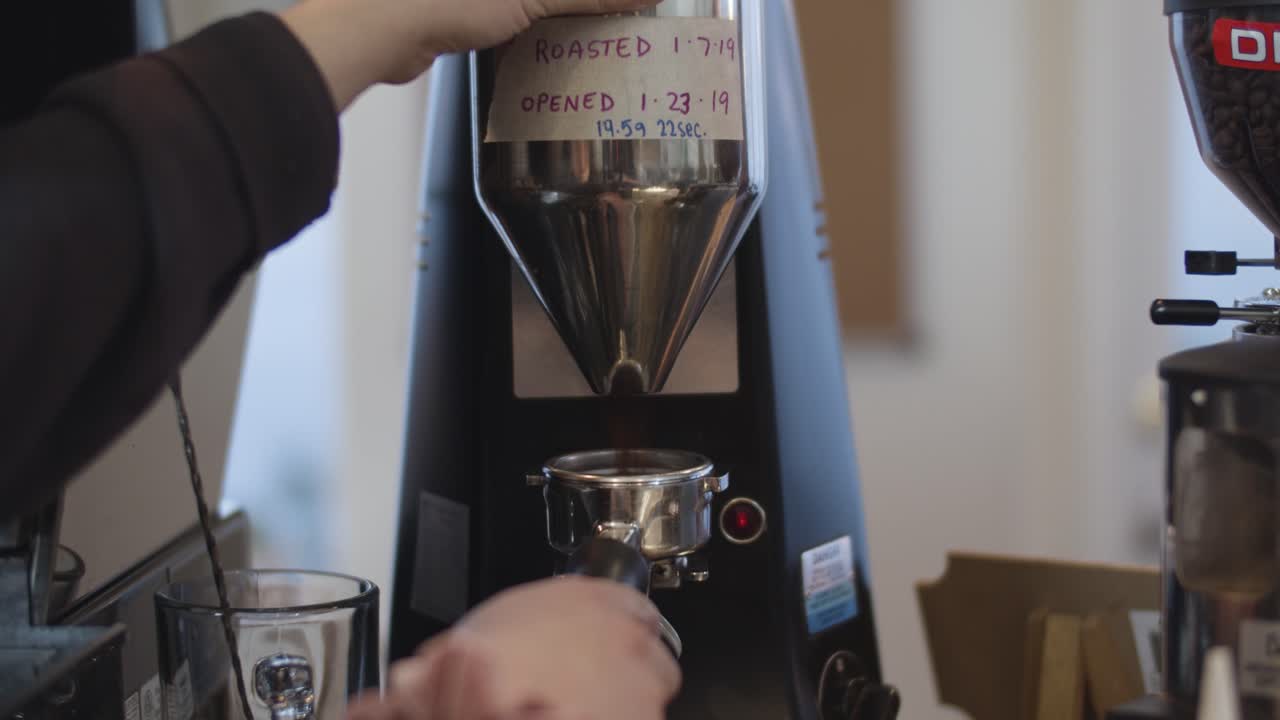 barista muele los granos de café espresso en tiro