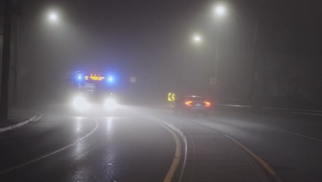 vehicles driving on foggy road at night - wide