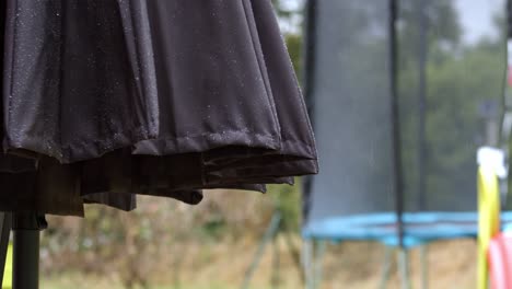 wet garden umbrella and trampoline during rainfall