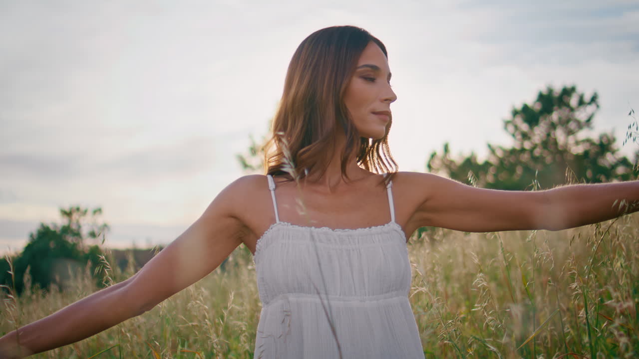 Tender girl touching spikelets enjoying meadow contemplating nature closeup