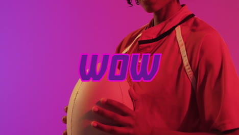 holding rugby ball with wow text in bold pink letters, person smiling