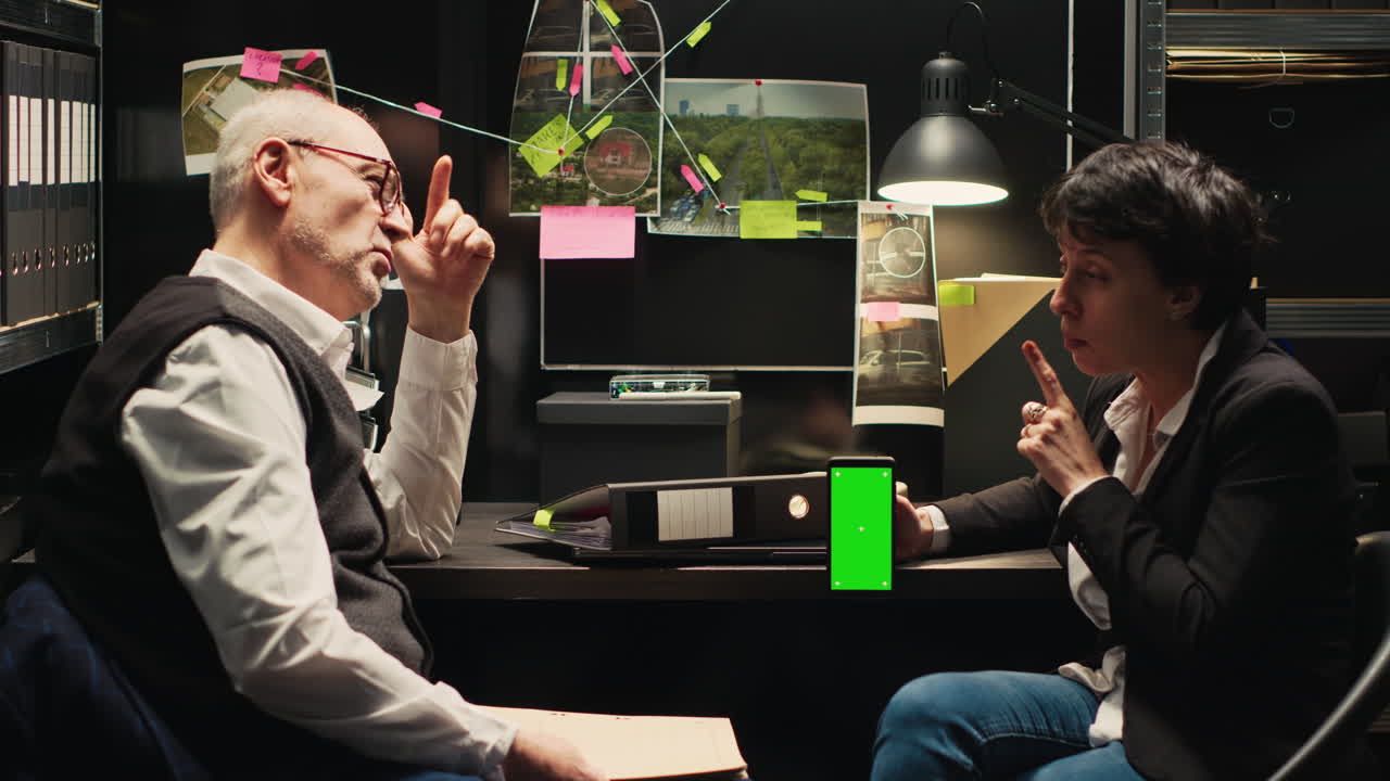 Detectives collaborating in office with green screen