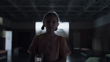 schoolgirl walking dark hallway alone. diverse students playing in hall shadow.